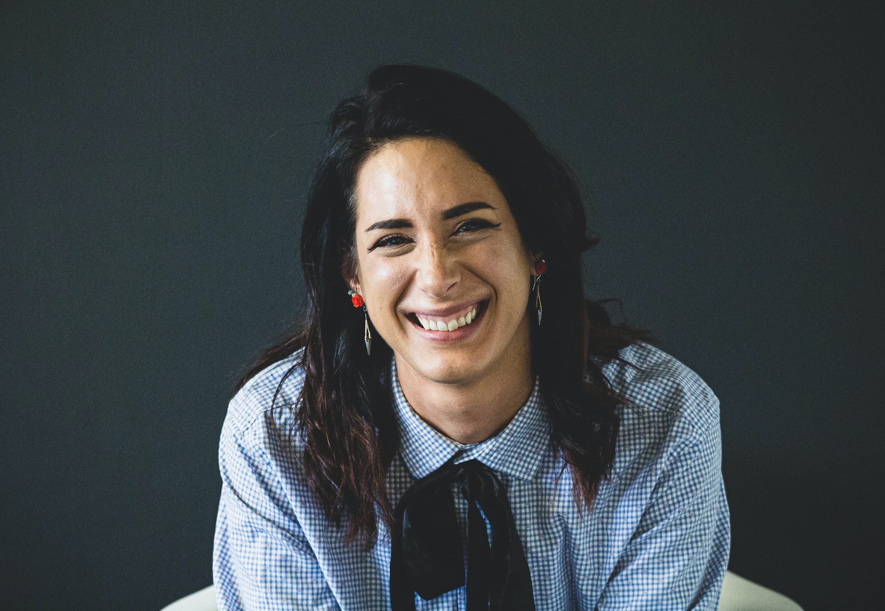 A blurry portrait of a woman. She is either smiling or crying.
